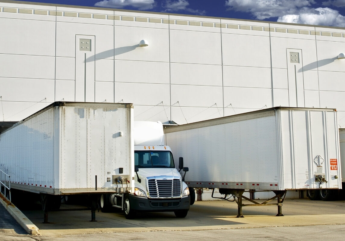 manual loading dock truck restraint on the left and a powered restraint with control panel on the right.